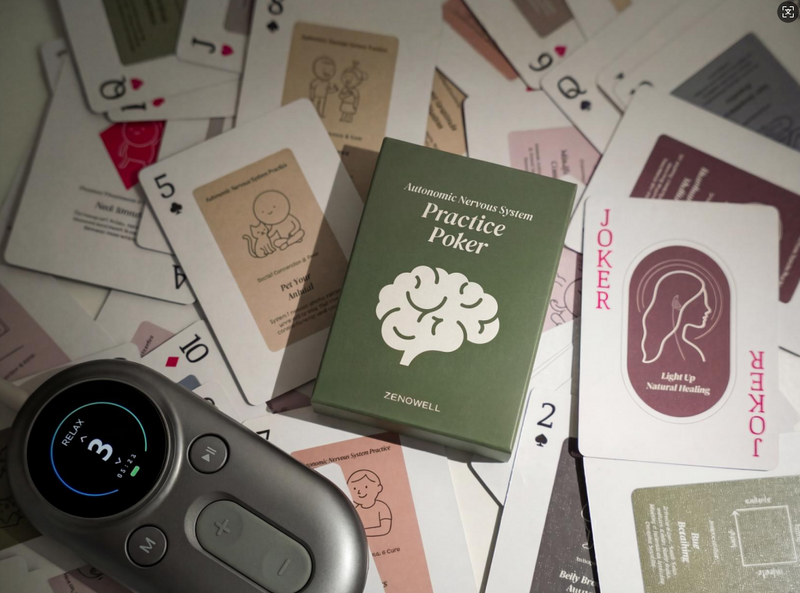 ZenoWell wearable device placed next to an ‘Autonomic Nervous System Practice Poker’ card deck, surrounded by scattered playing cards on a table.