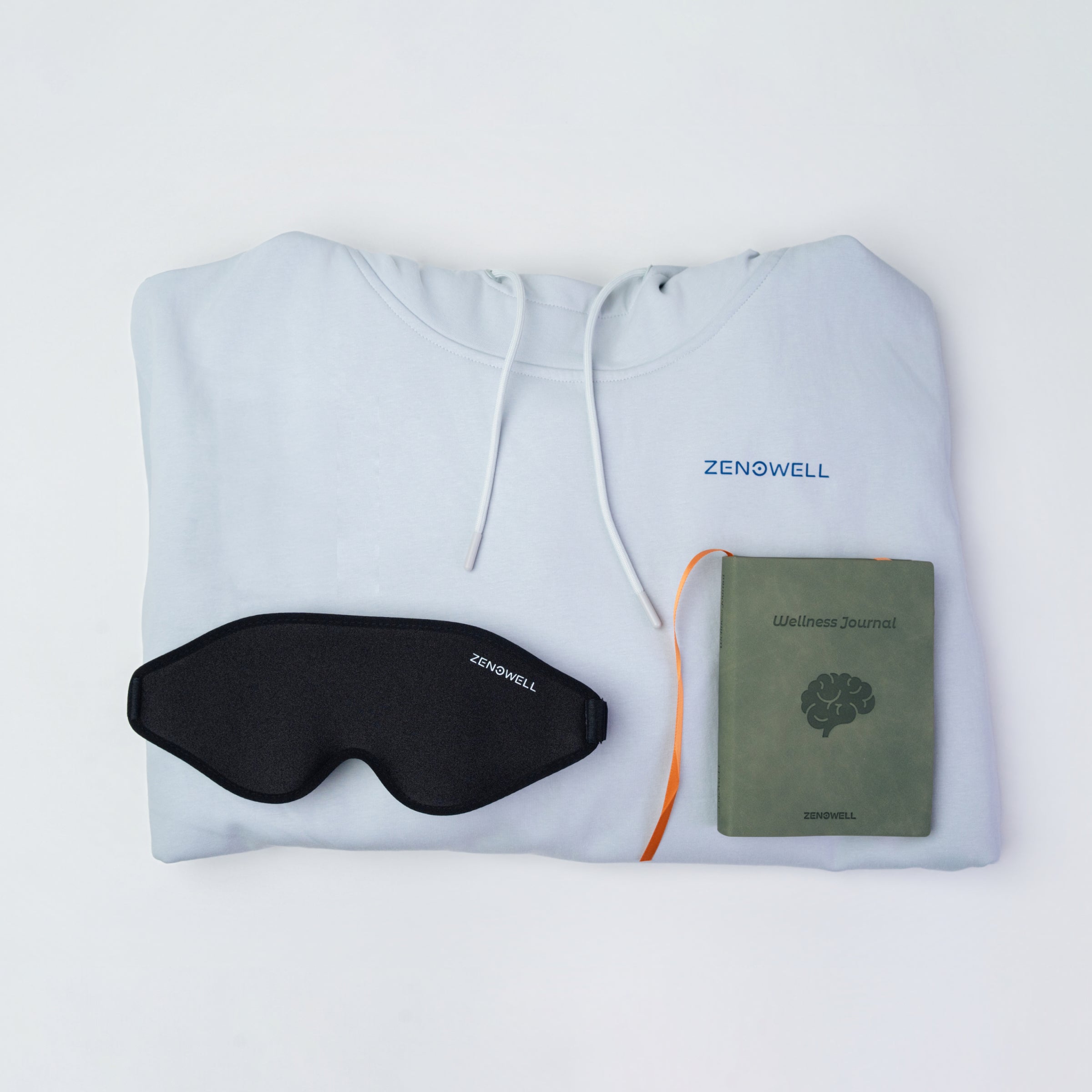 ZenoWell light blue hoodie, eye mask, and wellness journal, designed to support relaxation and mindfulness for improved well-being.
