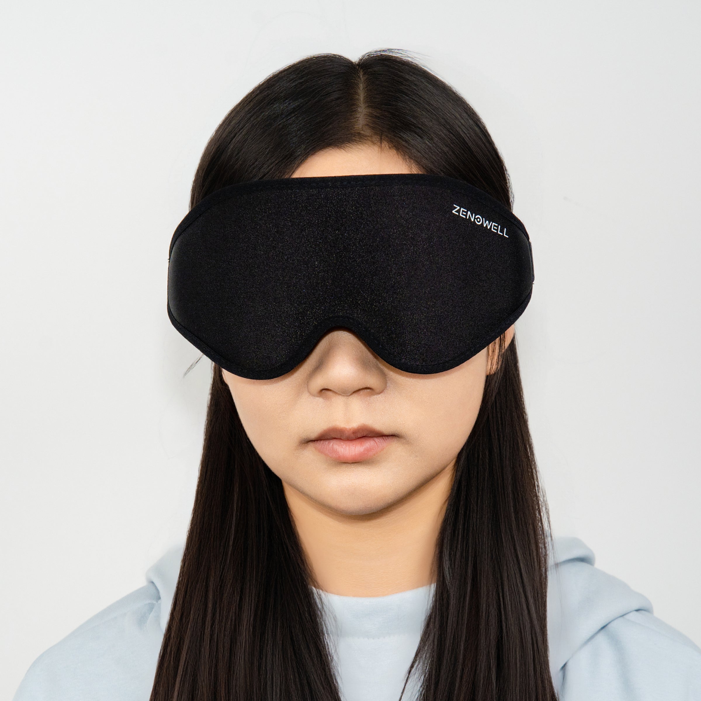 A person wearing a ZenoWell sleep mask, with the logo visible, the product from the front view.